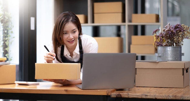 Mujer de negocios asiática que vende marketing comercial en línea en casa