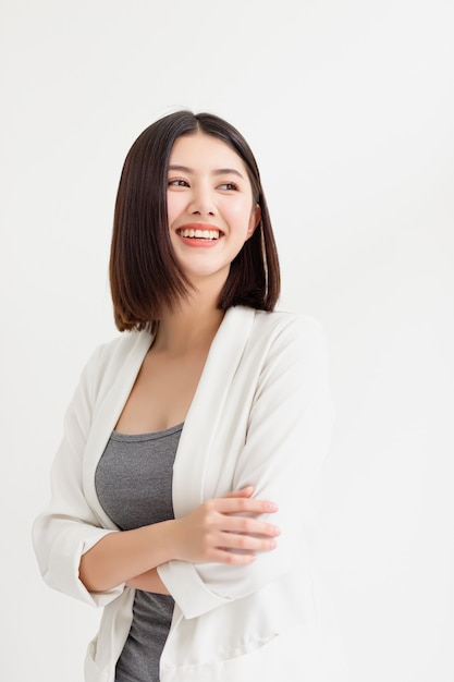 Foto mujer de negocios asiática sonriente de pie y mirando