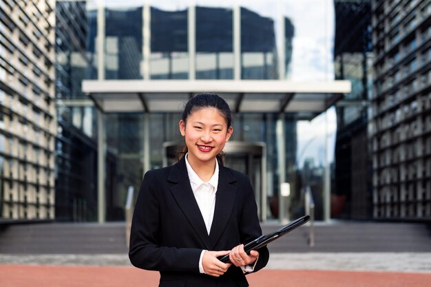 Mujer de negocios asiática sonriente que mira la cámara