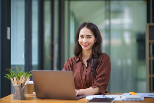 Mujer de negocios asiática trabajando con una computadora portátil en una oficina