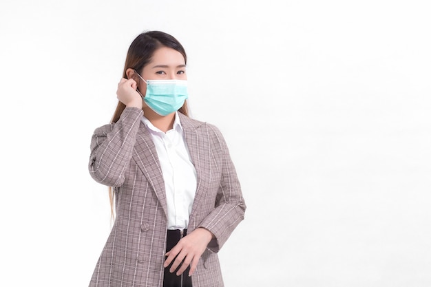 Mujer de negocios asiática usa traje formal y mascarilla médica para proteger la enfermedad infecciosa COVID19