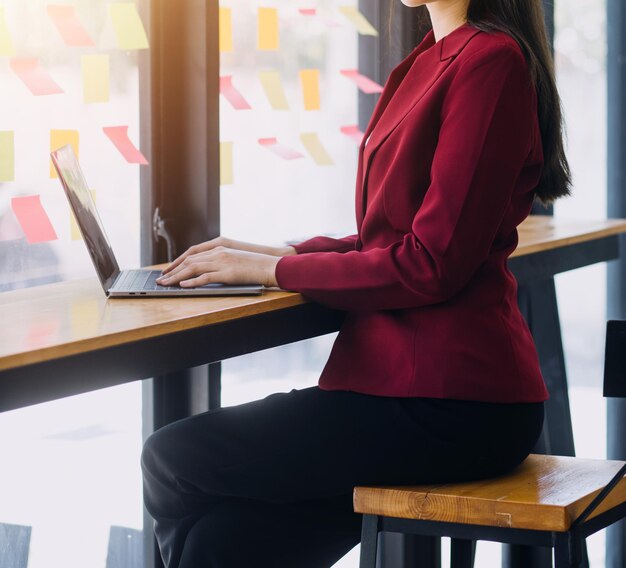 Mujer de negocios asiática usando calculadora y portátil para hacer finanzas matemáticas en un escritorio de oficina informe de impuestos estadísticas de contabilidad y concepto de investigación analítica
