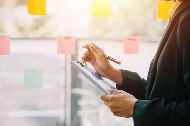 Mujer de negocios asiática usando calculadora y portátil para hacer finanzas matemáticas en un escritorio de oficina informe de impuestos estadísticas de contabilidad y concepto de investigación analítica