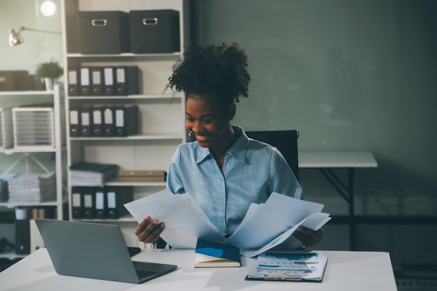 Mujer de negocios asiática Usando una computadora portátil y trabajando en la oficina con una calculadora documento en el escritorio haciendo planificación analizando el informe financiero plan de negocios concepto de análisis de finanzas de inversión