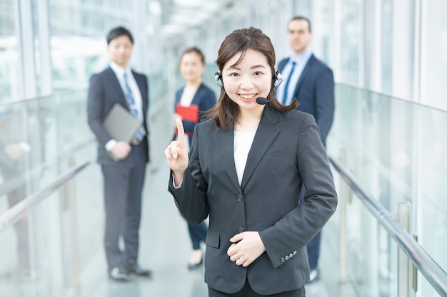 Mujer de negocios con un auricular y su equipo empresarial