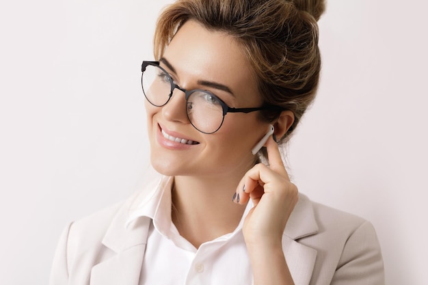 Mujer de negocios con auriculares inalámbricos en las orejas