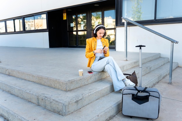 Mujer de negocios con auriculares sentada en las escaleras de la oficina