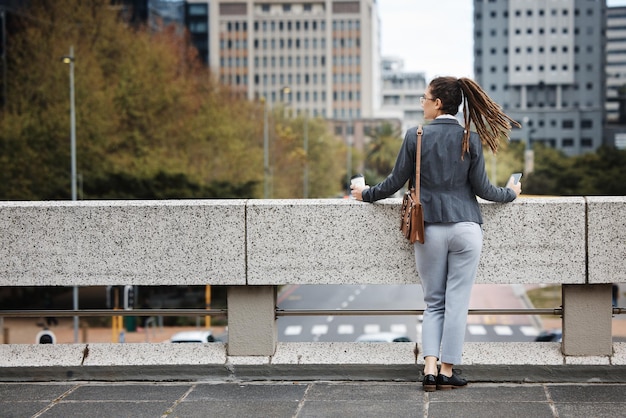 Foto mujer de negocios en la azotea de la ciudad y pensando con ideas, visión y planificación para una carrera futura o un objetivo de vida sueño de empresaria y lluvia de ideas con decisión de elección o mentalidad en metro cbd