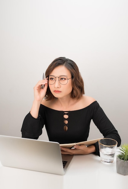 Mujer de negocios bastante asiática pensando en su escritorio en su oficina