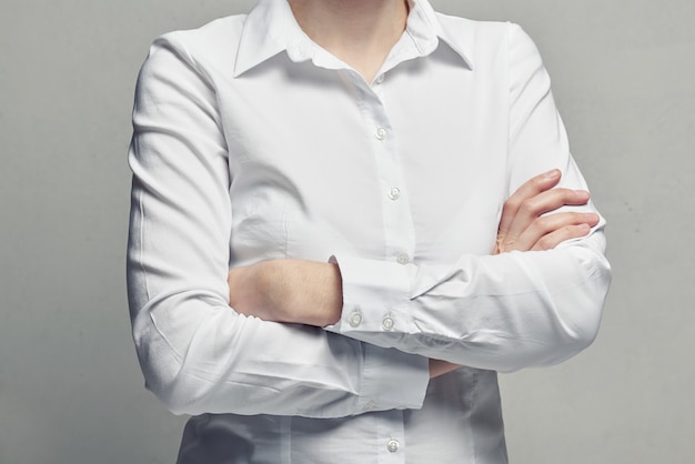 Mujer de negocios en una blusa blanca con los brazos cruzados