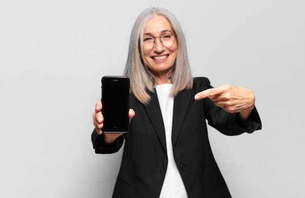 Mujer de negocios bonita senior con un teléfono inteligente.