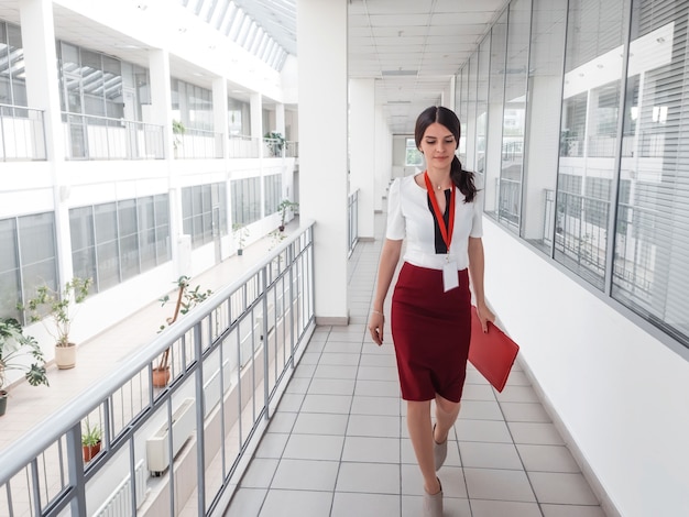 Mujer de negocios caminando por el pasillo de la oficina.