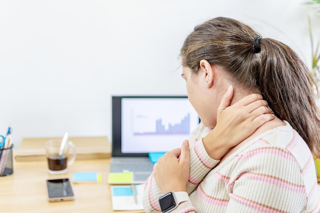 Foto mujer de negocios cansada y estresada que sufre de dolor de cuello trabajando desde la oficina en casa