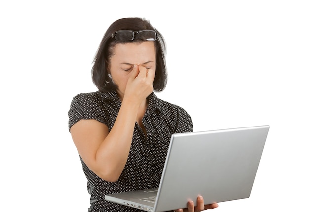 Mujer de negocios cansada en gafas trabajando en un portátil sobre un fondo blanco.