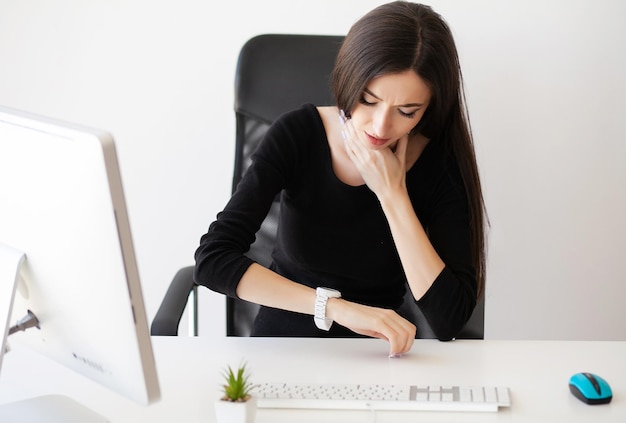 Mujer de negocios cansada sosteniendo su cuello