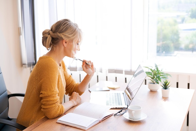 Mujer de negocios caucásica pensativa mirando hacia otro lado pensando en resolver el problema