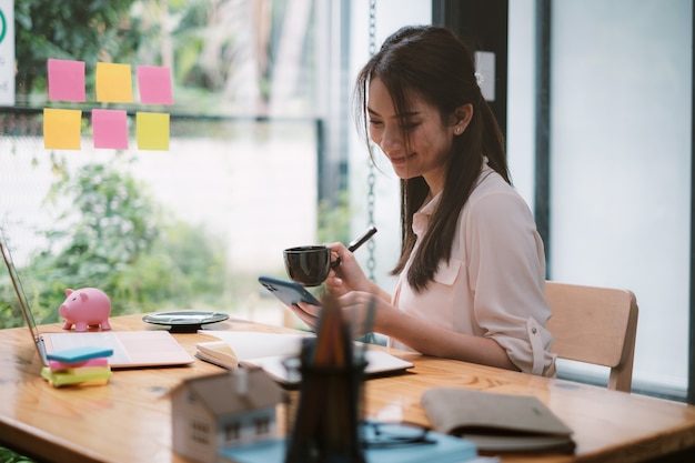 Una mujer de negocios completa KYC utilizando un programa de banca en línea para abrir una cuenta de ahorros digital. La definición de ciberseguridad.