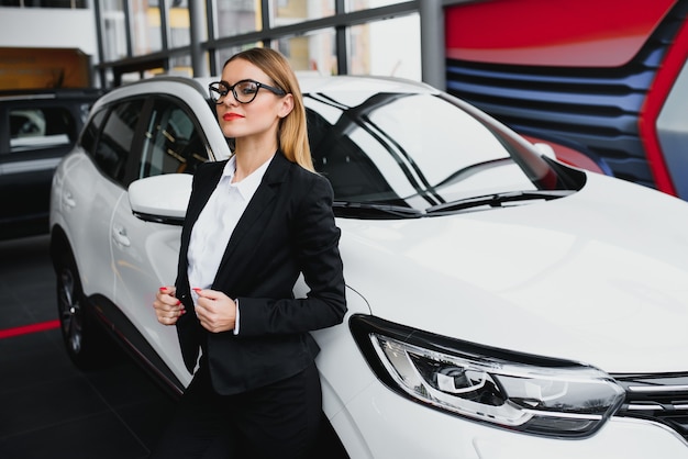 Mujer de negocios compra un coche en un concesionario de coches