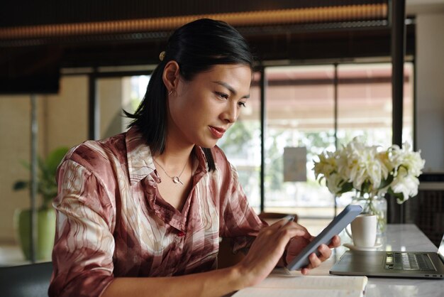 Mujer de negocios comprobando los mensajes de sus colegas