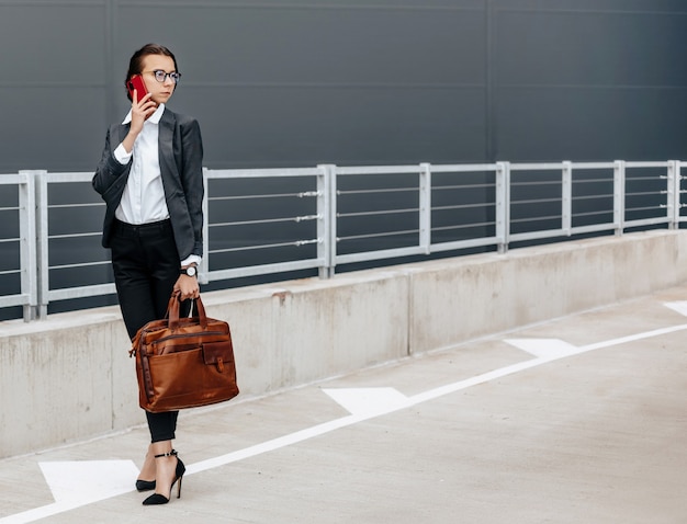 Una mujer de negocios comprueba la hora en la ciudad durante una jornada laboral esperando una reunión