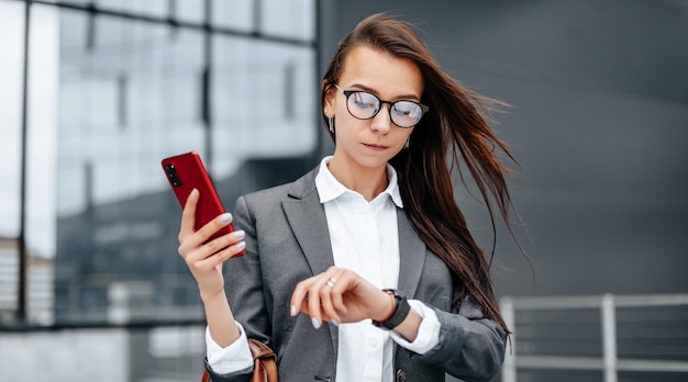 Una mujer de negocios comprueba la hora en la ciudad.