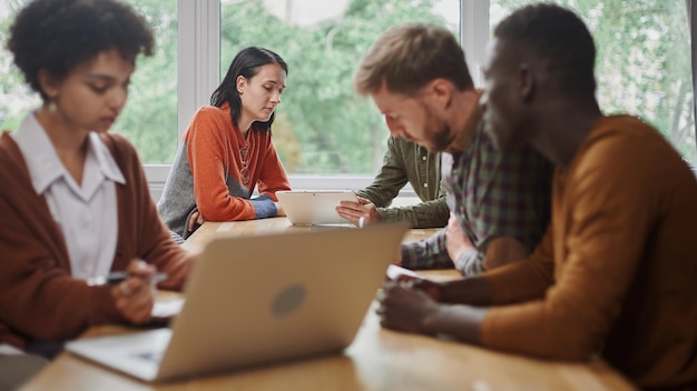 La mujer de negocios se comunica con un cliente sentado en una mesa en un centro de coworking