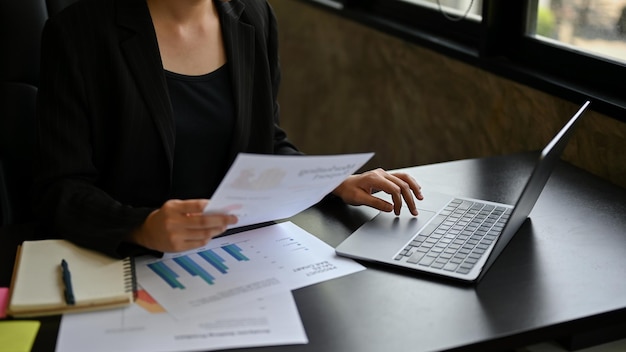 Una mujer de negocios se concentra en su trabajo revisando informes de marketing