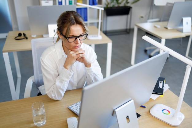 Mujer de negocios concentrada mirando la pantalla de la computadora