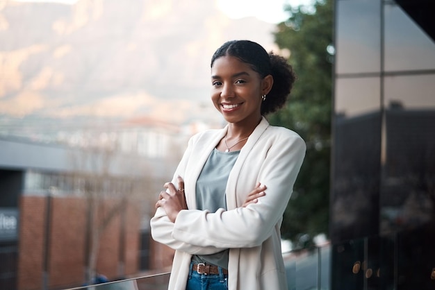 Mujer de negocios confiada con los brazos cruzados parada afuera de una oficina en el trabajo Retrato de un profesional corporativo feliz, sonriente y experto con los brazos cruzados trabajando en una empresa nueva