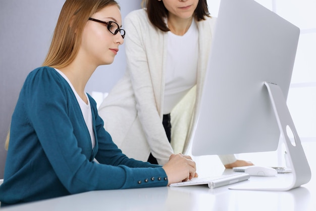 Foto mujer de negocios dando una presentación a su colega mientras se sientan en el escritorio