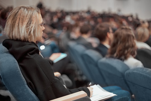 Mujer de negocios con documentos comerciales sentado en la sala de conferencias