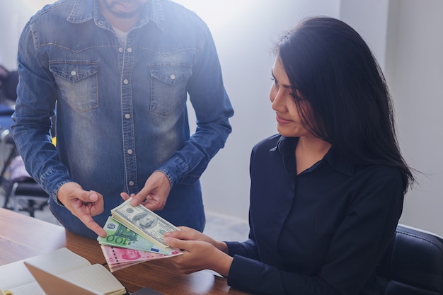 Mujer de negocios con dólares estadounidenses, yuan RMB, dinero en euros