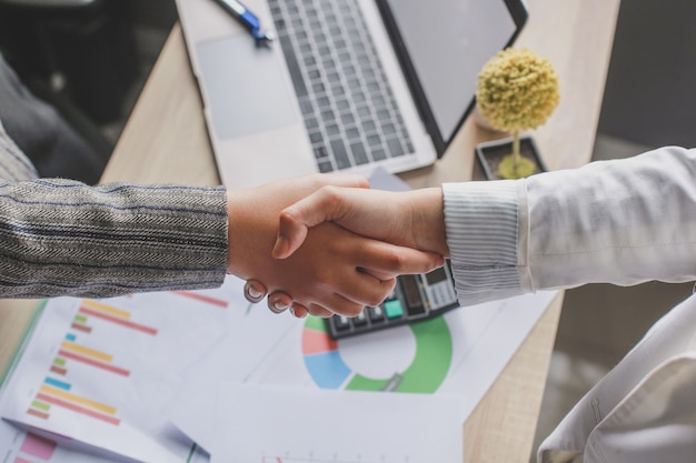 Mujer de negocios dos estrecharme la mano en la oficina