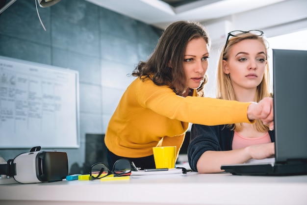 Mujer de negocios dos trabajando en la oficina y usando laptop