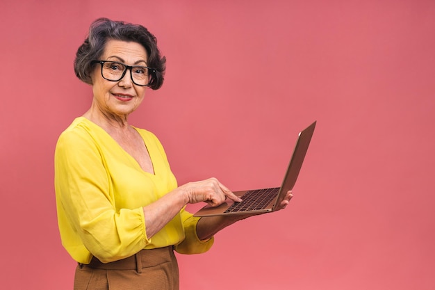 Foto mujer de negocios de edad avanzada con portátil abuela aislada sobre fondo rosa
