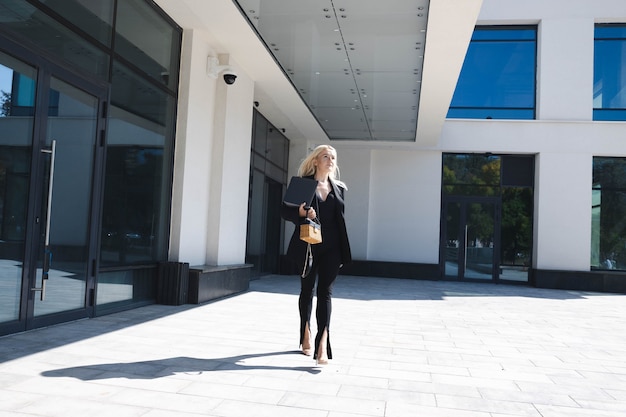 Una mujer de negocios con un elegante traje camina cerca del centro de negocios.