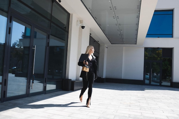 Foto una mujer de negocios con un elegante traje camina cerca del centro de negocios.