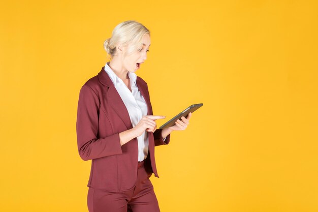 Mujer de negocios es sorprendente en fondo amarillo studio