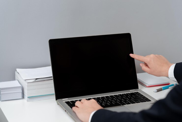 Foto mujer de negocios escribiendo actualizaciones recientes en el teclado de la computadora portátil en el escritorio y señalando ideas importantes con un dedo mujer en la oficina escribiendo mensajes tardíos en la computadora