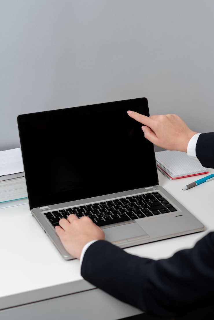 Foto mujer de negocios escribiendo actualizaciones recientes en el teclado de la computadora portátil en el escritorio y señalando ideas importantes con un dedo mujer en la oficina escribiendo mensajes tardíos en la computadora