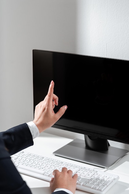 Mujer de negocios escribiendo actualizaciones recientes en el teclado de la computadora portátil en el escritorio y señalando ideas importantes con un dedo mujer en la oficina escribiendo mensajes tardíos en la computadora