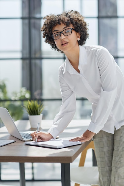 Foto mujer de negocios escribiendo en su escritorio en una oficina moderna