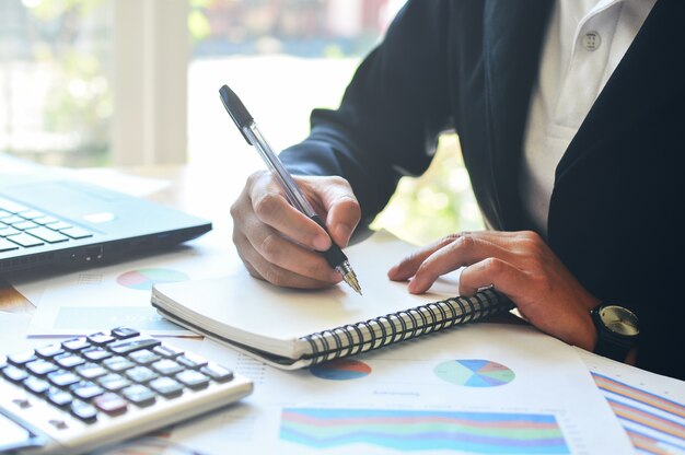 Mujer de negocios por escrito en el cuaderno