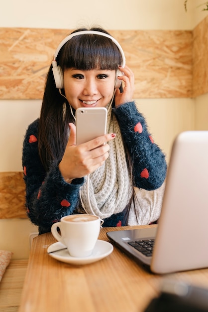 Mujer de negocios escuchando música en la cafetería. Concepto de negocio