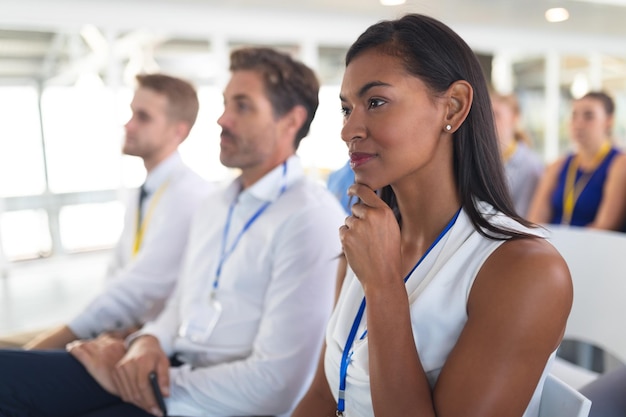 Foto mujer de negocios escuchando a un orador en un seminario de negocios