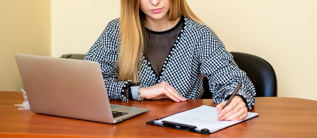 Mujer de negocios está escribiendo en un documento