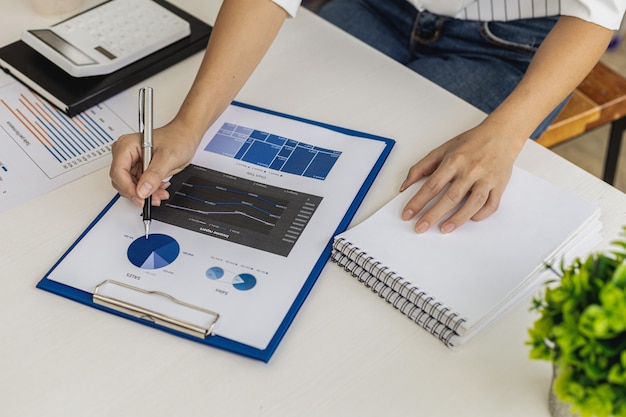 La mujer de negocios está mirando los documentos financieros de la empresa para analizar problemas y encontrar soluciones antes de llevar la información a una reunión con un socio. Concepto financiero.