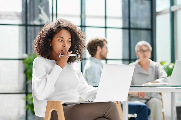 La mujer de negocios está trabajando en una computadora portátil en la oficina