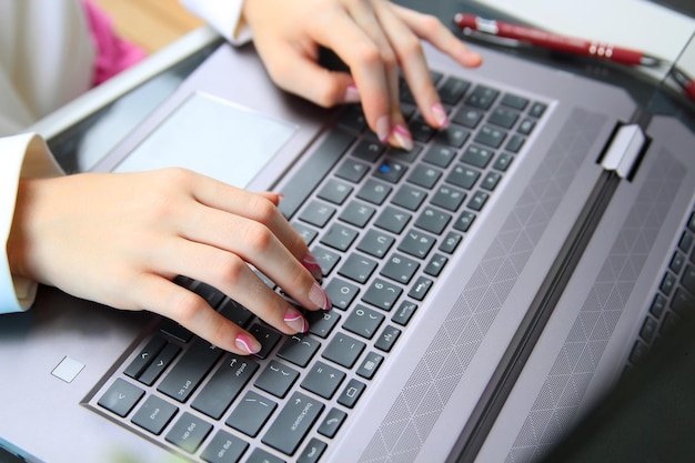 La mujer de negocios está trabajando con gráficos en una computadora portátil en la oficina