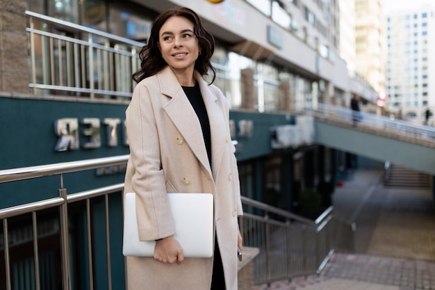 Mujer de negocios con estilo con una computadora portátil en sus manos en ninguna sociedad